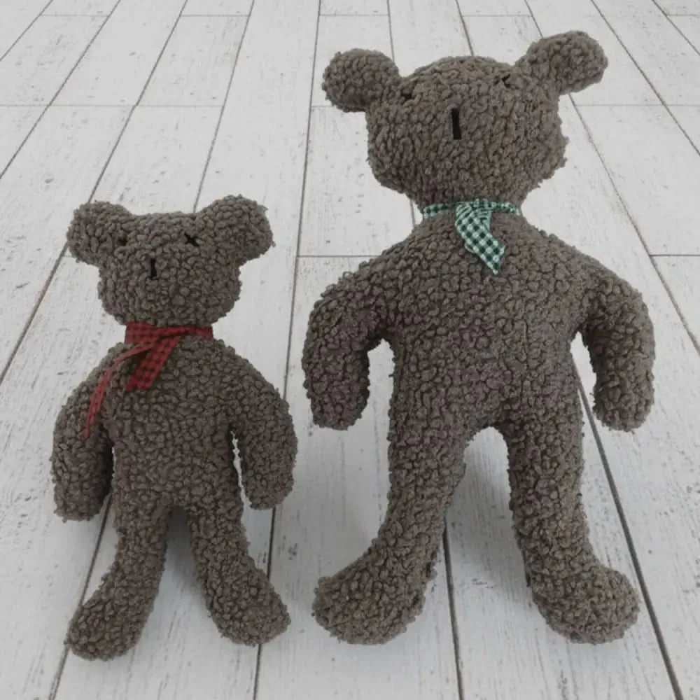 Zwei plüschteddy charly paddy stone in verschiedenen größen mit rotem band und grün kariertem hundehalsband