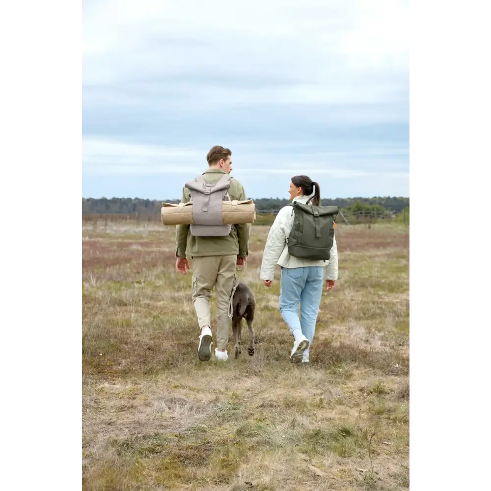 Zwei Leute und Hund beim Wandern mit Rolltop Rucksack Yoska auf dem Rücken