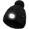 Die Pfotenimglueck-Mütze mit LED-Beleuchtung und Bommel in Schwarz, mit Bommel und integriertem LED-Licht auf der Vorderseite, ist perfekt für winterliche Outdoor-Aktivitäten.