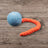 Blaue Jumping Schleuder-Filzball aus regionaler Bio-Schurwolle mit orangefarbenem Schwanz für Hundespielzeug