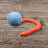 Blaue Jumping Schleuder-Filzball aus regionaler Bio-Schurwolle mit orangefarbenem Schwanz für Hundespielzeug