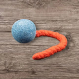 Blaue Jumping Schleuder-Filzball aus regionaler Bio-Schurwolle mit orangefarbenem Schwanz für Hundespielzeug