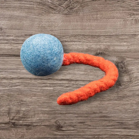 Blaue Jumping Schleuder-Filzball aus regionaler Bio-Schurwolle mit orangefarbenem Schwanz für Hundespielzeug
