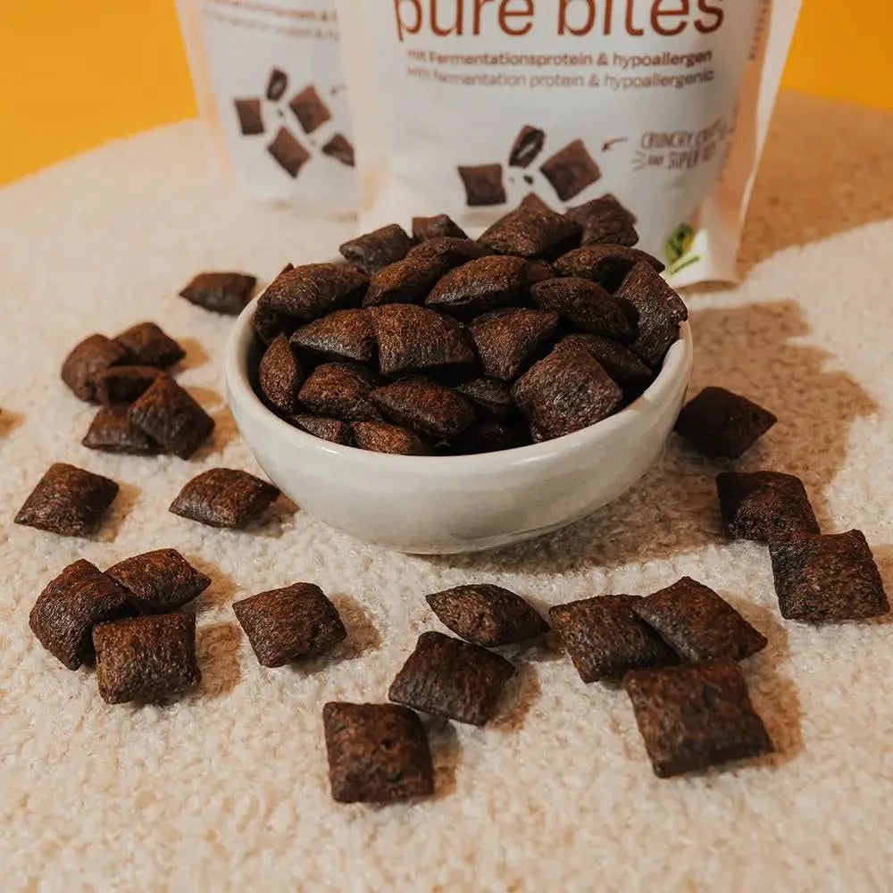 Weiße schüssel mit dunkelbraunen pure bites protein snacks als hundespielzeug alternative